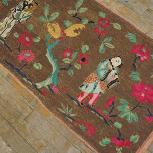 Brown embroidered runner with vibrant pink and teal floral and figurative motifs on distressed wood.