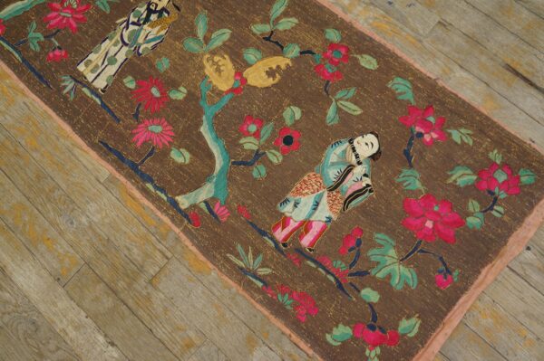 Brown embroidered runner with vibrant pink and teal floral and figurative motifs on distressed wood.