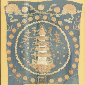 Framed blue textile featuring a central pagoda design, gold coiled circles, and stylized cloud patterns.