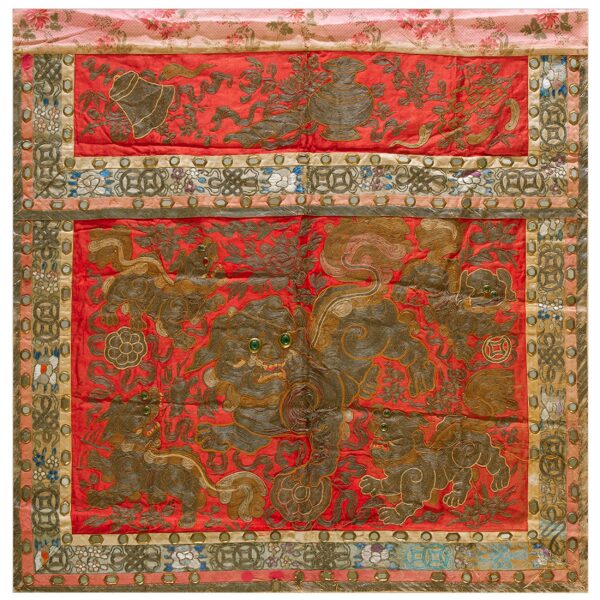 Red embroidered textile panel featuring gold mythical lions, geometric borders, and small reflective embellishments.