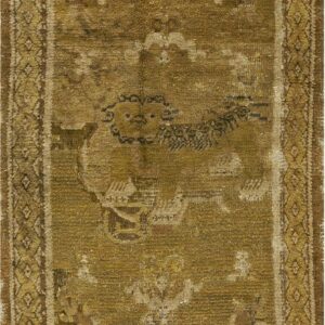 A heavily worn rug displaying olive and brown tones with a central animal motif and diamond borders.