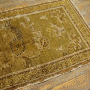 Distressed, low-pile runner rug with faded medallion and geometric borders on rustic wooden plank flooring.
