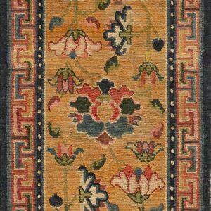 Golden yellow runner rug displaying multicolored florals and a geometric key border surrounded by dark blue.