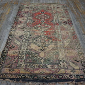 Distressed geometric runner rug featuring muted red, beige, and green on gray wood planks.
