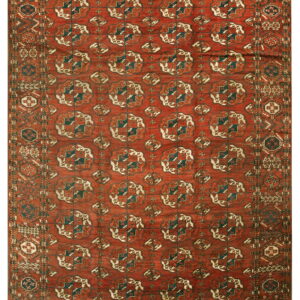 A rust-red geometric rug features repeating dark teal, cream, and brown Gul motifs in the central field.