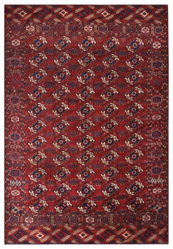A richly patterned rug with a deep red field and repeating navy blue and cream geometric medallions.
