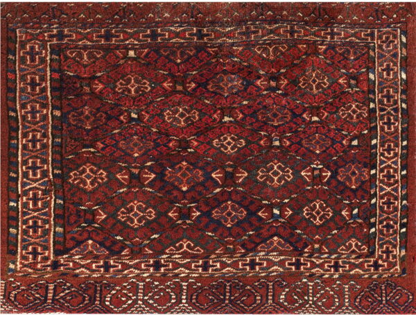 Red rug with a dense geometric field pattern and elaborate borders in navy, black, and cream colors.