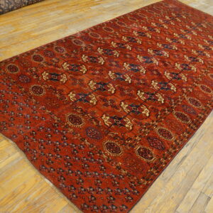 Long red rug with blue and tan geometric patterns displayed on light hardwood floors.
