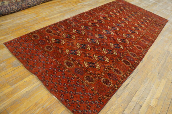 Long red rug with blue and tan geometric patterns displayed on light hardwood floors.