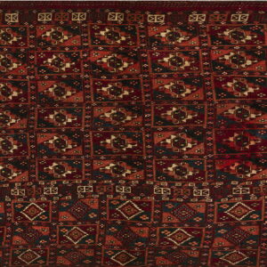 Burgundy and burnt orange rug with a dense repeating geometric pattern of dark medallion and diamond motifs.