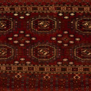 A deep red geometric rug featuring large, repeating octagonal medallions and multiple detailed borders.