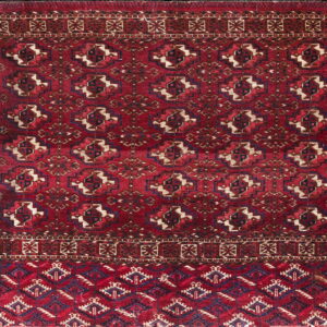 Dark red rug with repeating geometric medallions in navy, tan, and secondary patterned border designs.