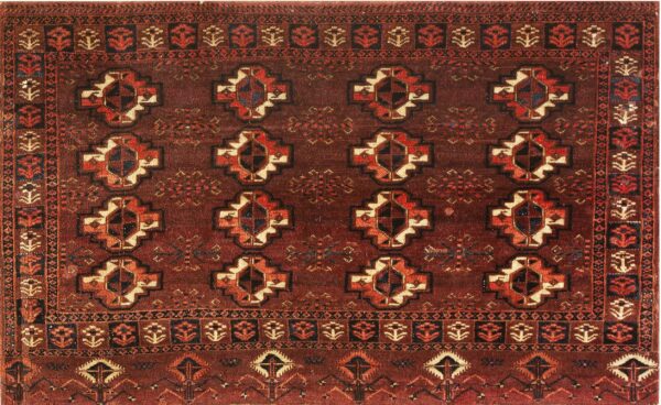 Reddish-brown rug with complex geometric patterns and repeating medallions in rust, cream, and navy.