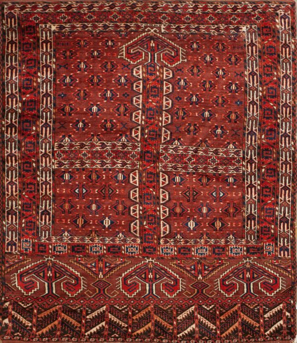 Traditional deep red rug with intricate geometric motifs and striped borders in blue, cream, and red.