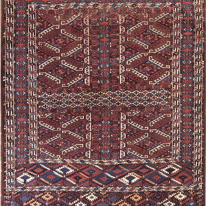 Geometric rug in deep browns, blues, and reds, featuring intricate tribal designs and stepped elements.