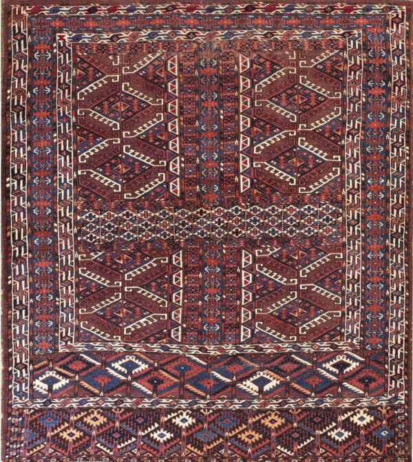 Geometric rug in deep browns, blues, and reds, featuring intricate tribal designs and stepped elements.