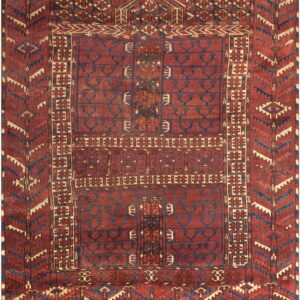 Deep red rug with complex geometric designs, dark blue motifs, and a vertically segmented field.
