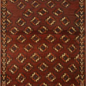 Deep red geometric rug featuring repeating stepped medallions and complex geometric borders in tan and navy.