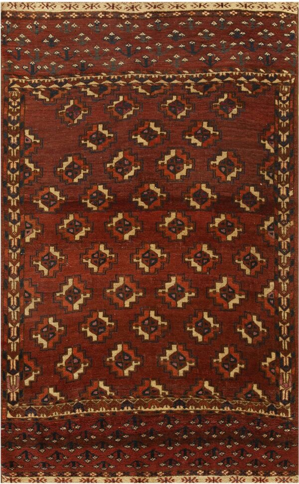 Deep red geometric rug featuring repeating stepped medallions and complex geometric borders in tan and navy.