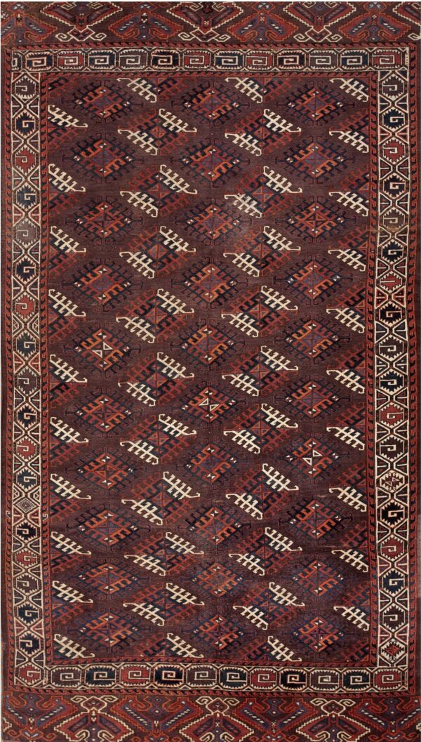 Deep brown rug with repeating geometric tribal patterns in rust, cream, and dark blue.