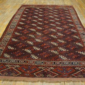 A long, dark geometric rug featuring rust, navy, and cream patterns is displayed on a light wooden floor.
