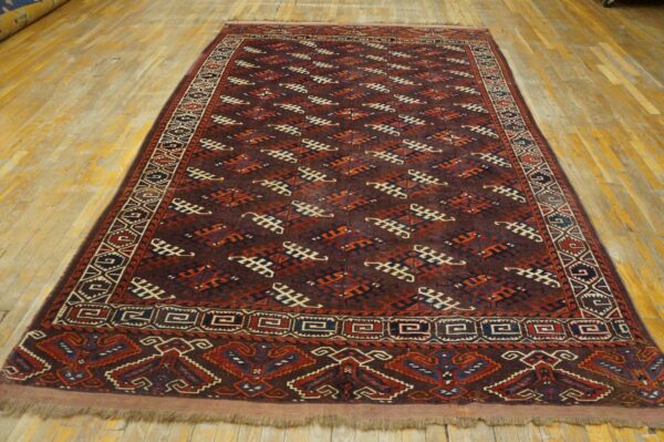 A long, dark geometric rug featuring rust, navy, and cream patterns is displayed on a light wooden floor.