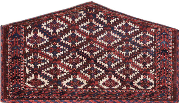 Deep red rug with a peaked shape and repeating blue and cream geometric medallions.