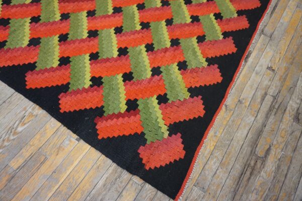 Low-pile rug with a vibrant red, lime green, and black basketweave geometric pattern on rustic wood flooring.