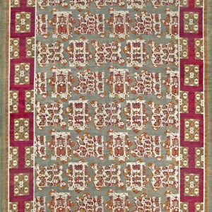 A rectangular rug featuring a gray field with geometric red and white repeating motifs, framed by a magenta border.
