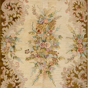 Cream rug featuring a large multicolored floral spray surrounded by a dark brown acanthus leaf border.