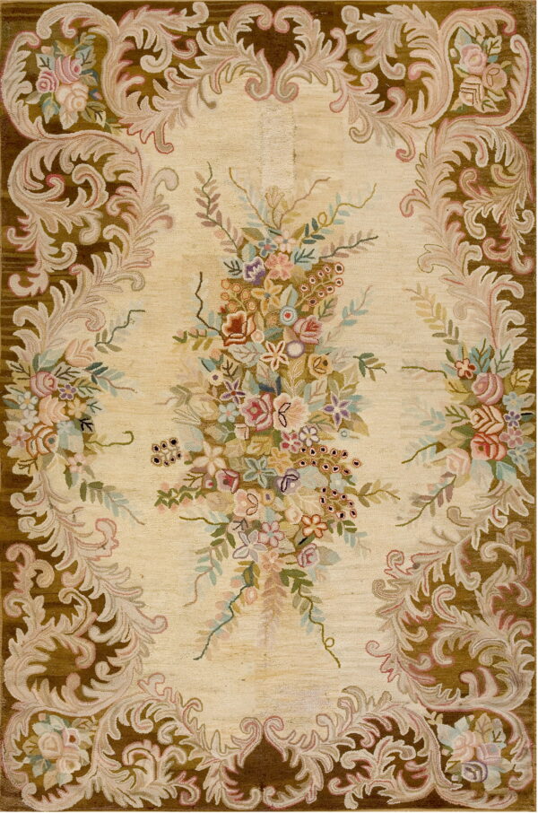 Cream rug featuring a large multicolored floral spray surrounded by a dark brown acanthus leaf border.