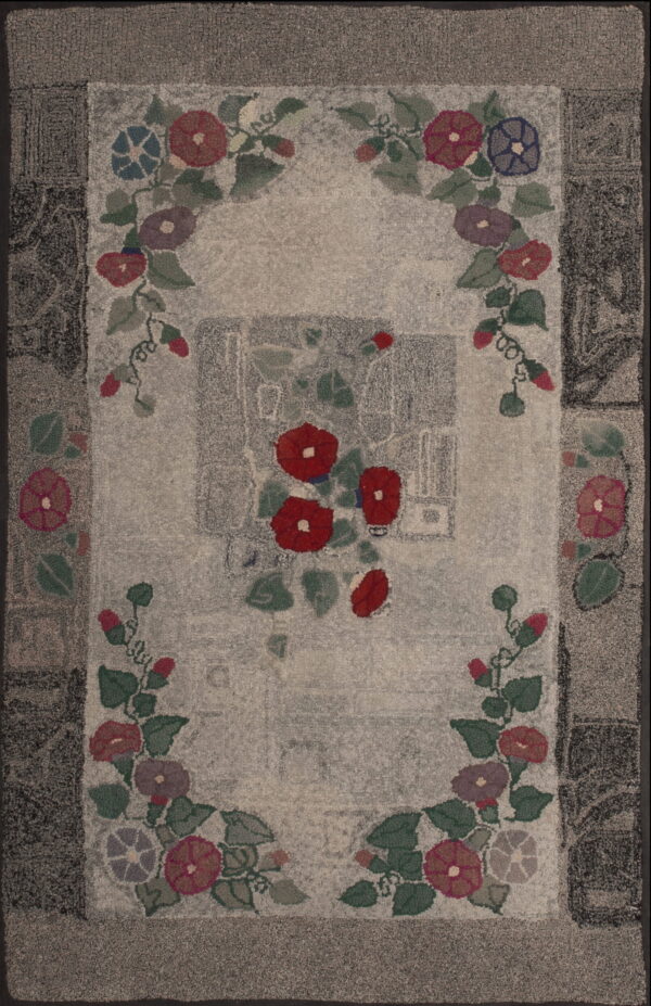Hooked rug with a light gray field, a dark border, and colorful floral garland motifs in red, blue, and green.