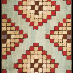 Geometric rug featuring red, brown, and cream checked diamonds against a textured pale blue background.
