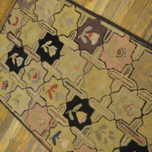 Muted yellow runner with black, pink, and purple geometric floral shapes shown on aged wood planks.
