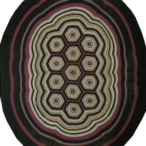 Round rug with black, burgundy, gray, and green concentric rings surrounding a central honeycomb pattern.