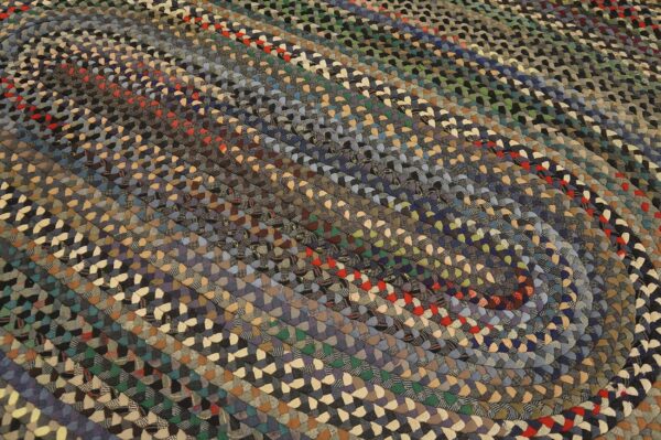 Muted multicolored braided rug featuring visible strands of blue, gray, red, and tan woven fabric.