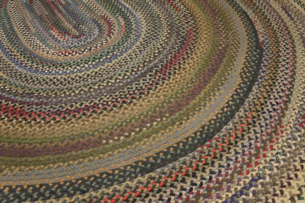 Close-up of a multi-colored braided rug showing concentric oval rings of blue, gray, brown, and red accents.