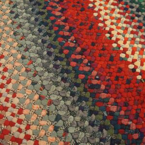 Highly textured braided rug showing wide diagonal stripes of red, gray, tan, and dark green.