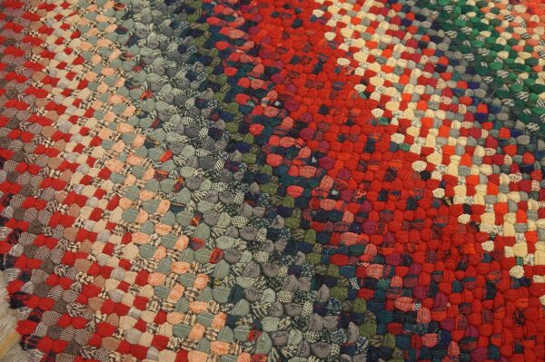 Highly textured braided rug showing wide diagonal stripes of red, gray, tan, and dark green.