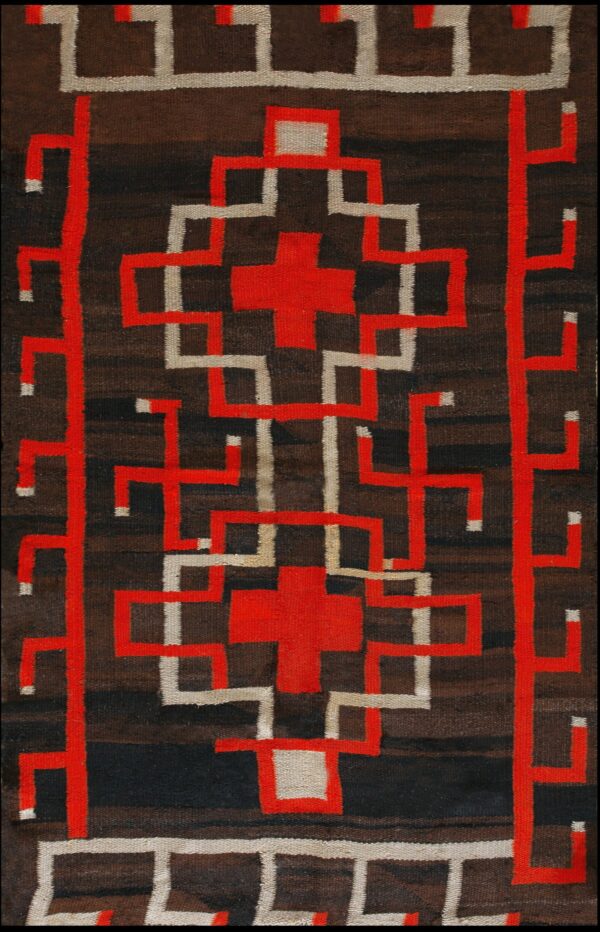 Dark brown flatweave rug featuring a central interlocking maze design in bold red and off-white geometric lines.