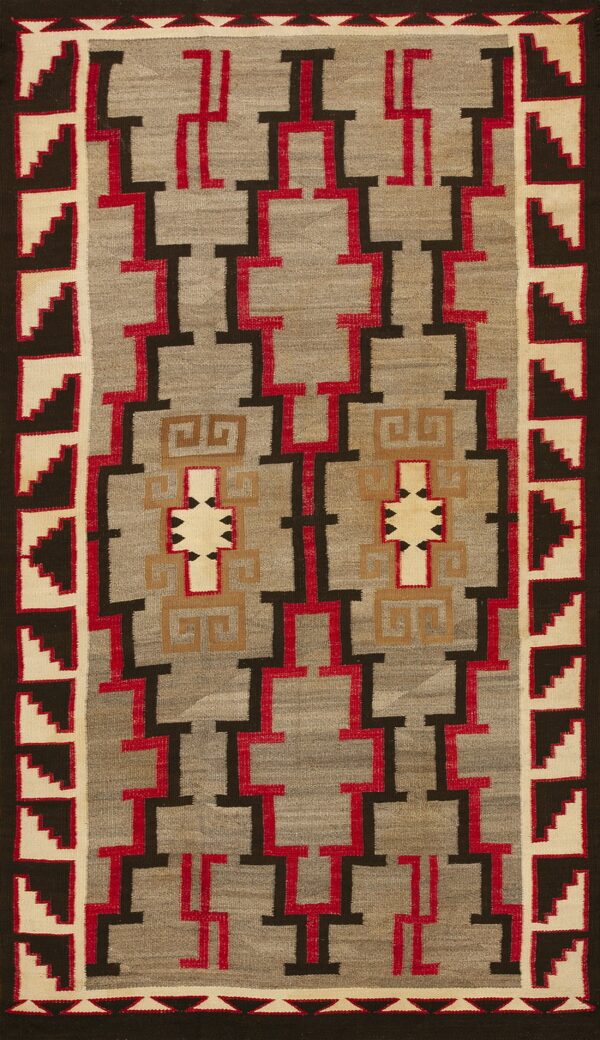 Gray flatweave rug with a dark brown, red, and tan interlocking geometric pattern and stepped borders.