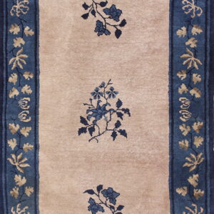 Beige runner rug with a wide blue floral border and three central blue floral sprays.