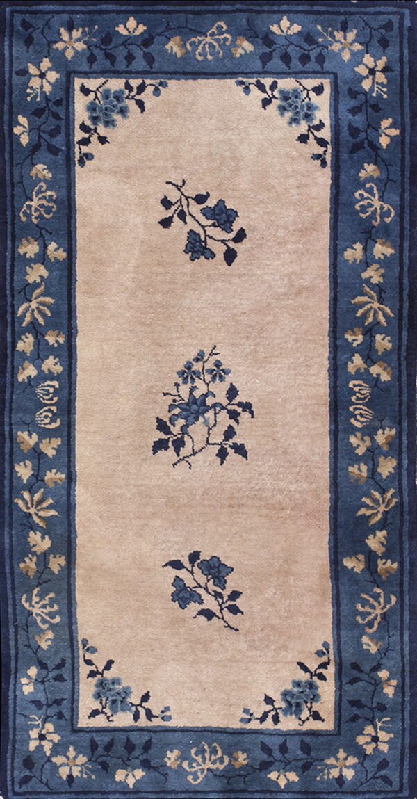 Beige runner rug with a wide blue floral border and three central blue floral sprays.
