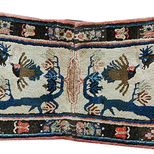 Notched, folded textile displaying symmetrical animal patterns in blue, cream, dark brown, and coral colors.