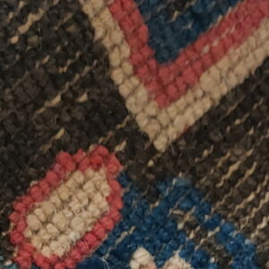 Close-up shows a contrasting rug design with shaggy blue and white pile next to geometric stripes.