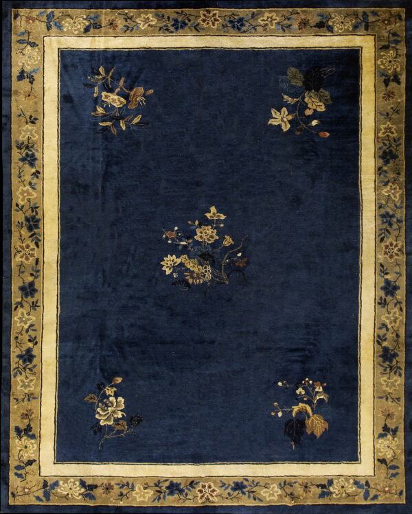 Navy blue rug with scattered golden floral designs and a wide cream and olive botanical border.