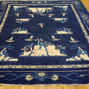 Large navy blue rug with light-colored, detailed scenic patterns of islands and boats on wood flooring.