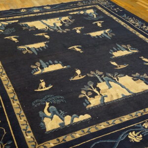 Dark blue rug with a light blue and tan landscape pattern displayed on wooden planks.