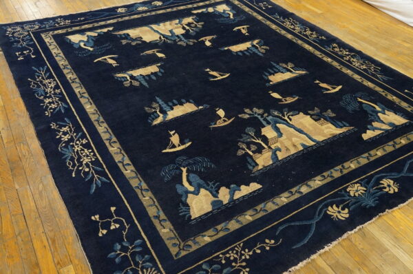 Navy rug with tan and blue islands, trees, and boats, framed by a floral border on wood planks.