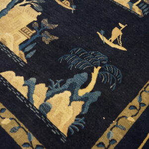 Navy blue rug featuring a traditional landscape pattern in tan, teal blue, and olive green tones.